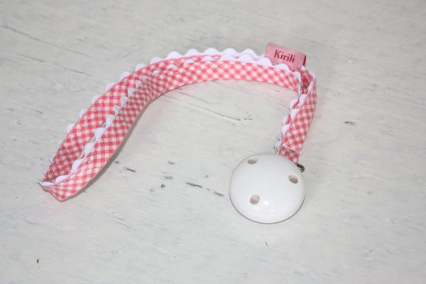Schnullerkette von Kirili. Baumwollband in Vichy-Karo. Farben: Rosa und weiß.